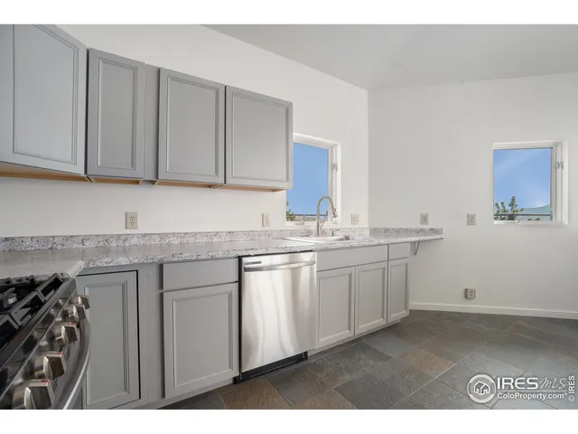 a kitchen with granite countertop a sink and dishwasher with cabinets