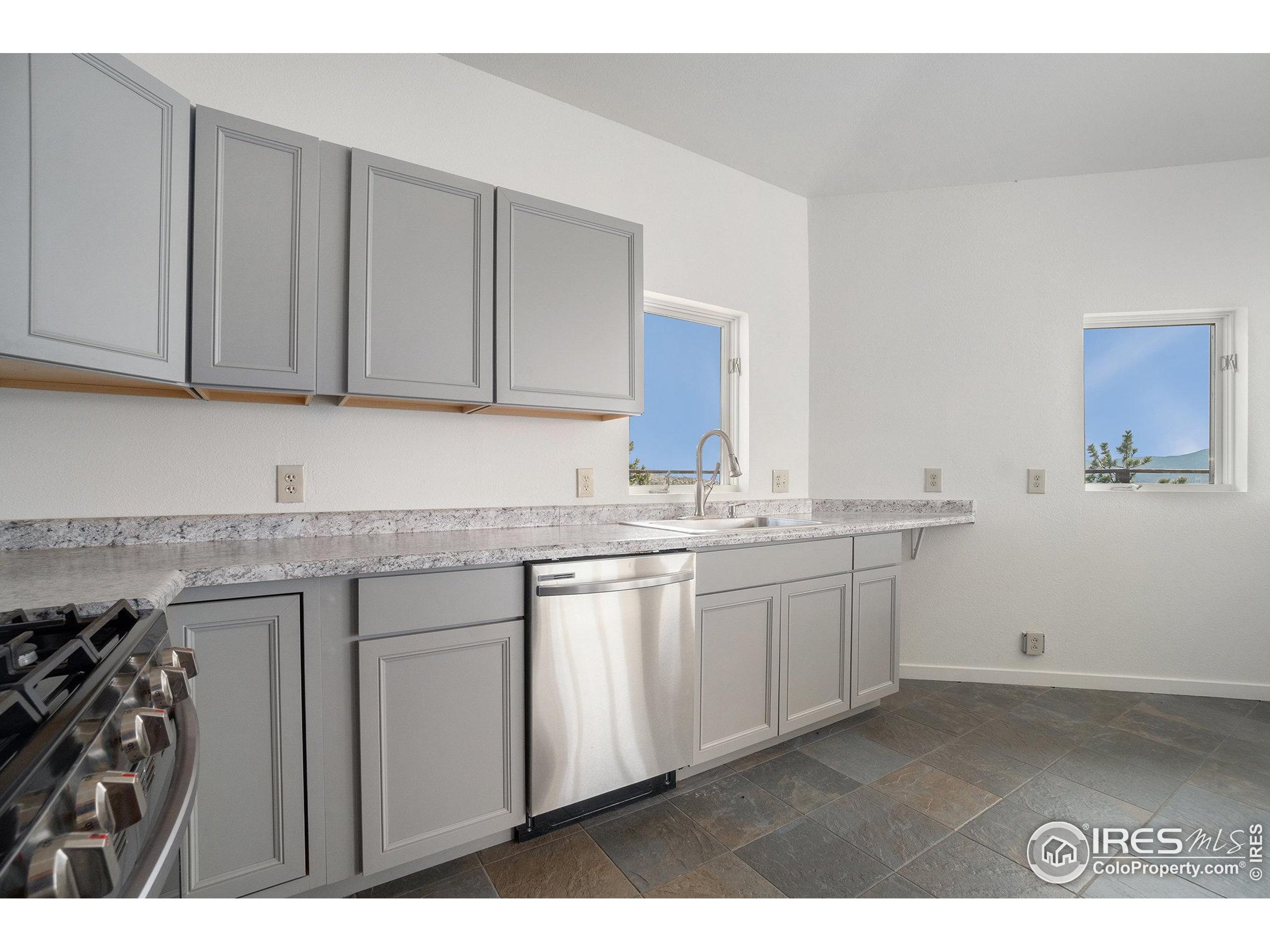 552 Blue Grouse Lane Bellvue, CO 80512 - Photo 11 of 39 a kitchen with granite countertop a sink and dishwasher with cabinets