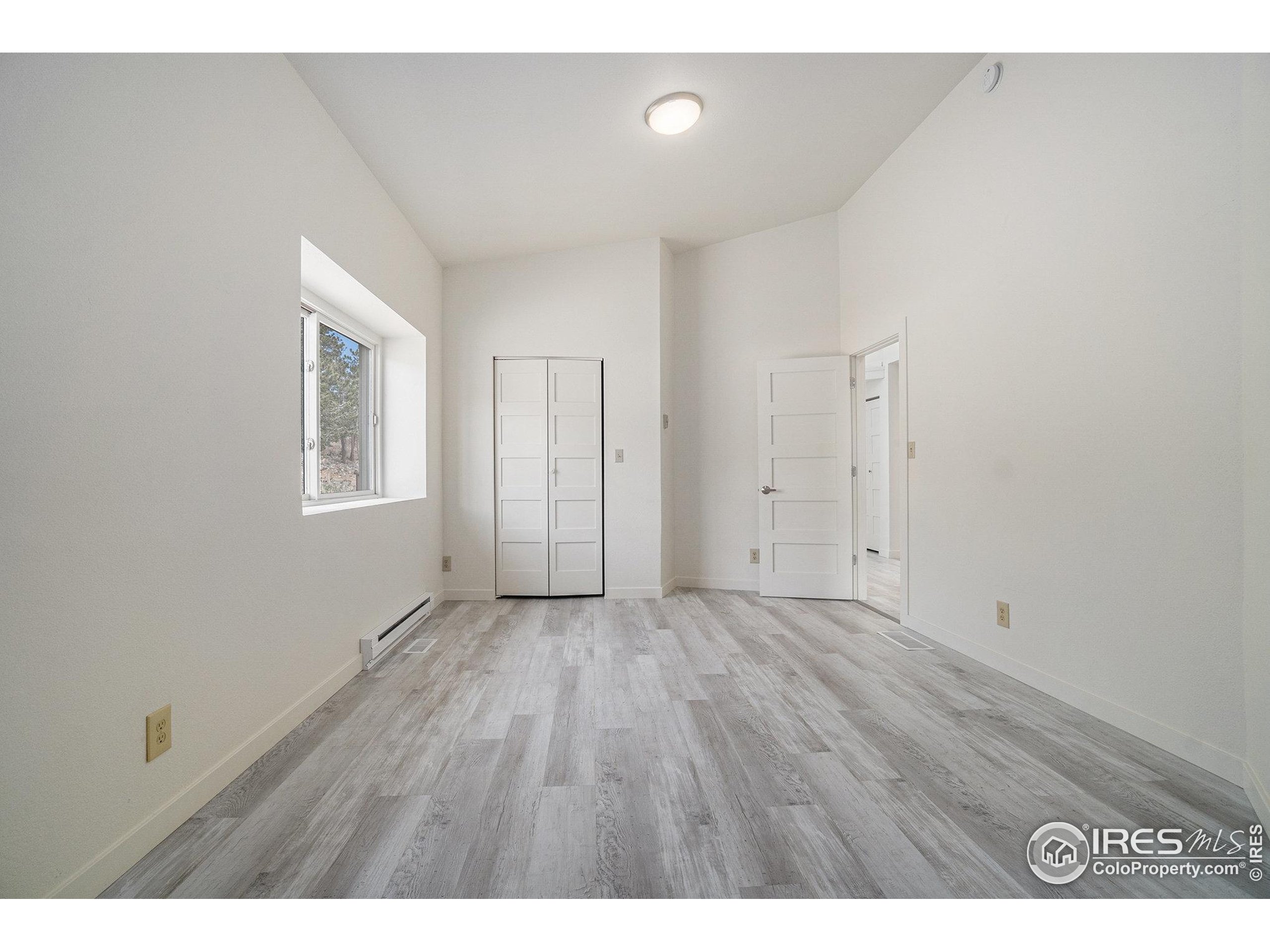 552 Blue Grouse Lane Bellvue, CO 80512 - Photo 13 of 39 a view of an empty room with wooden floor
