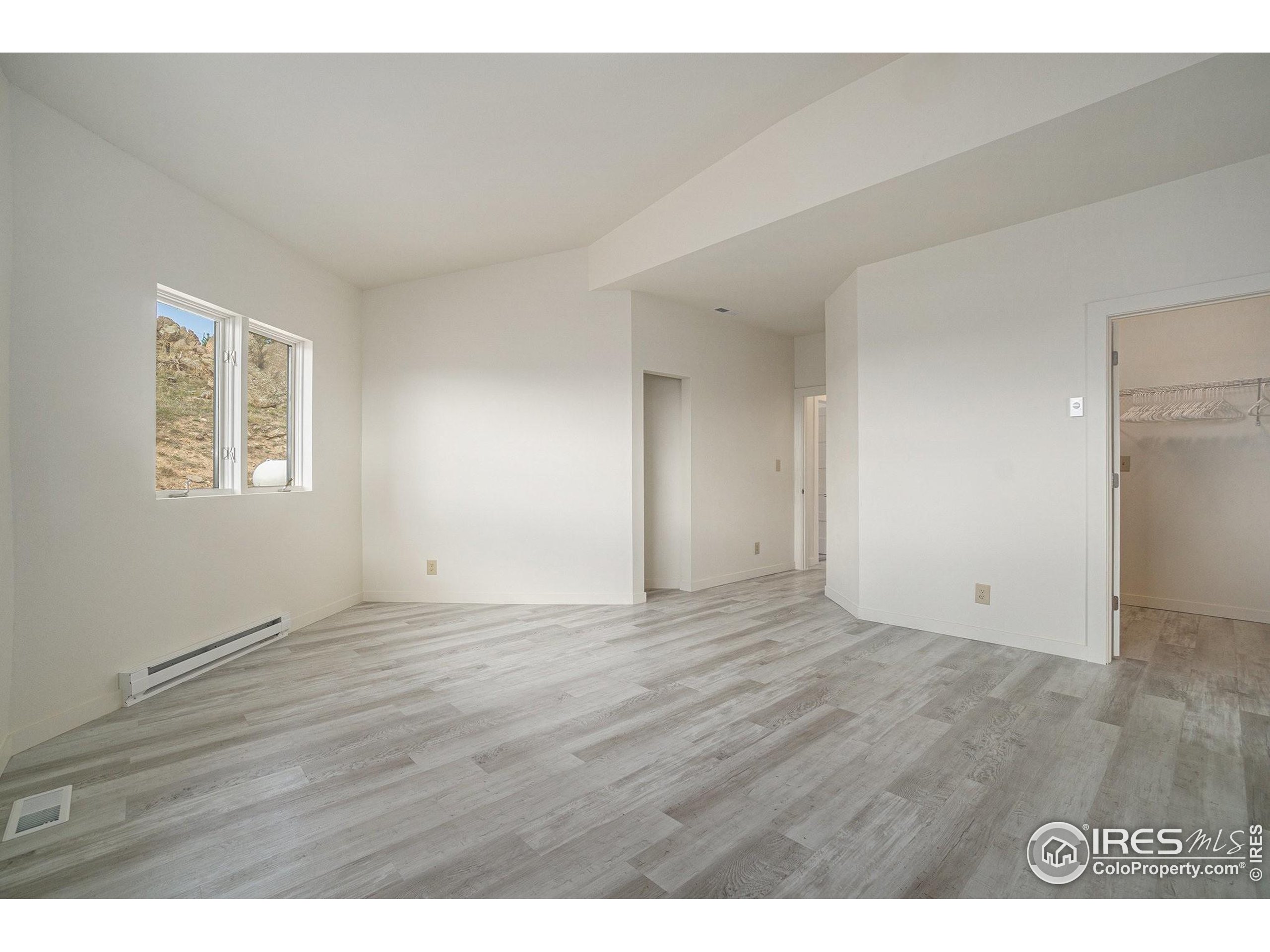 552 Blue Grouse Lane Bellvue, CO 80512 - Photo 21 of 39 a view of an empty room with wooden floor and a window