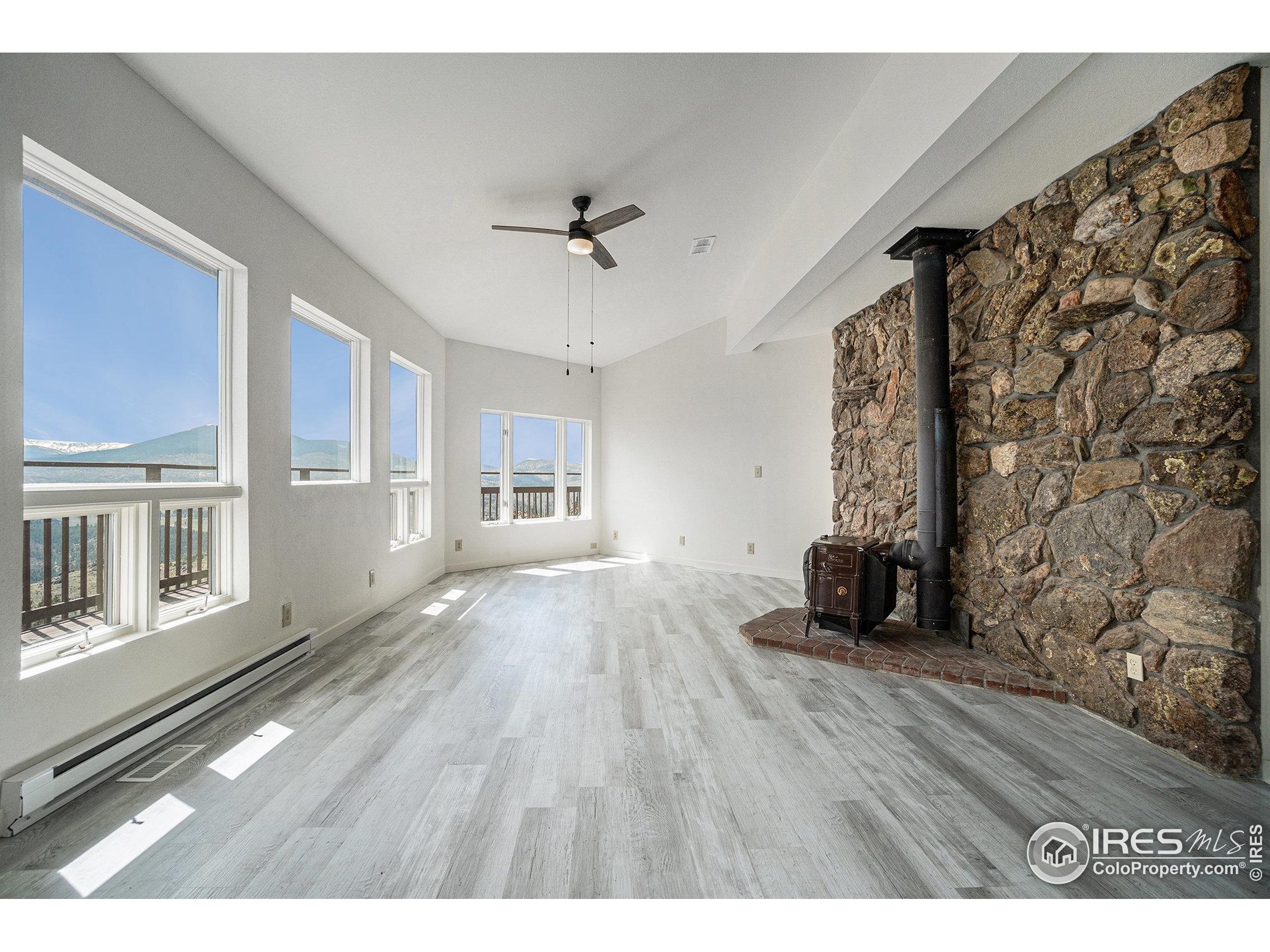 552 Blue Grouse Lane Bellvue, CO 80512 - Photo 7 of 39 a view of empty room with wooden floor and fan