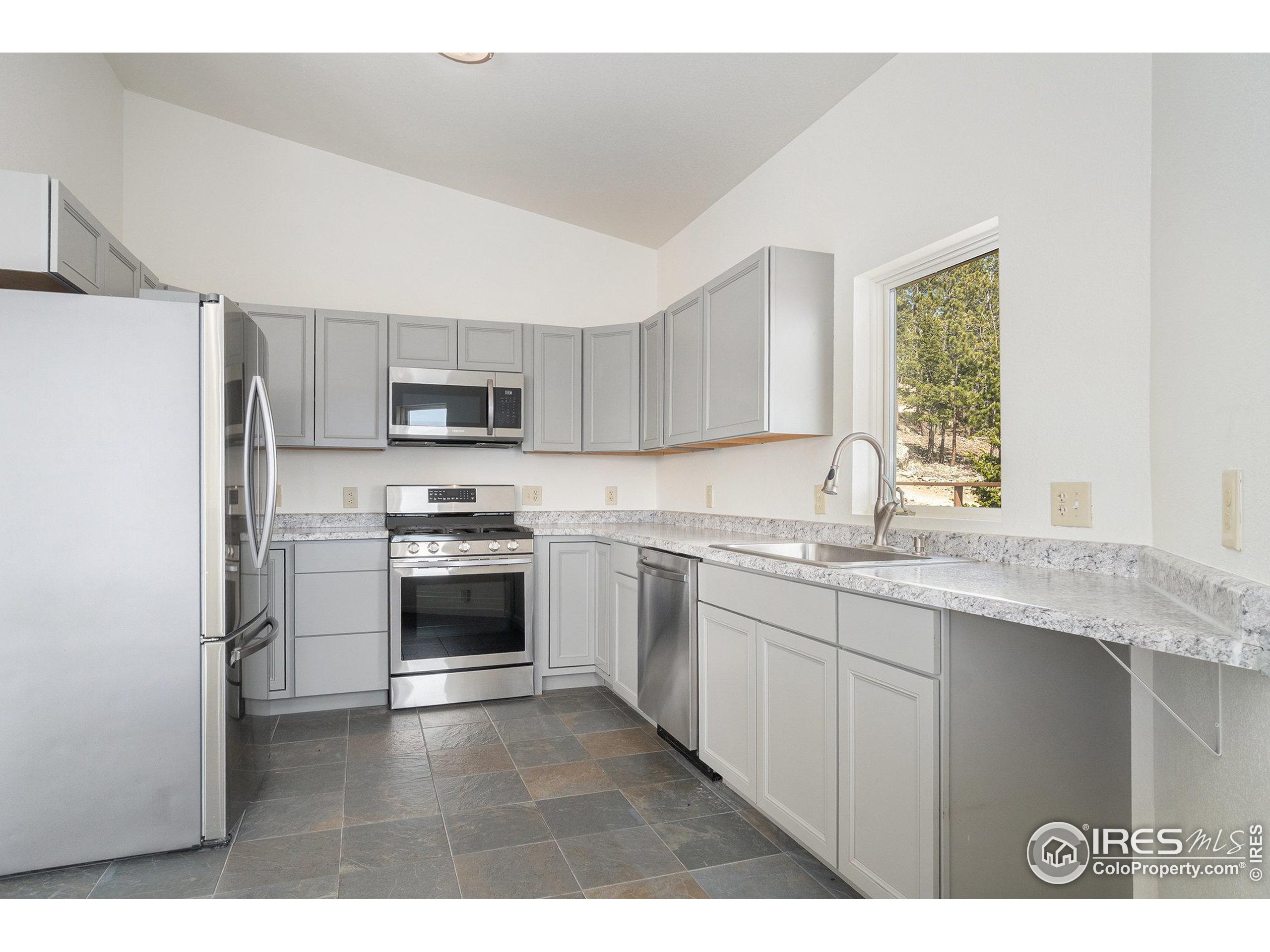 552 Blue Grouse Lane Bellvue, CO 80512 - Photo 9 of 39 a kitchen with granite countertop a stove a sink and a refrigerator