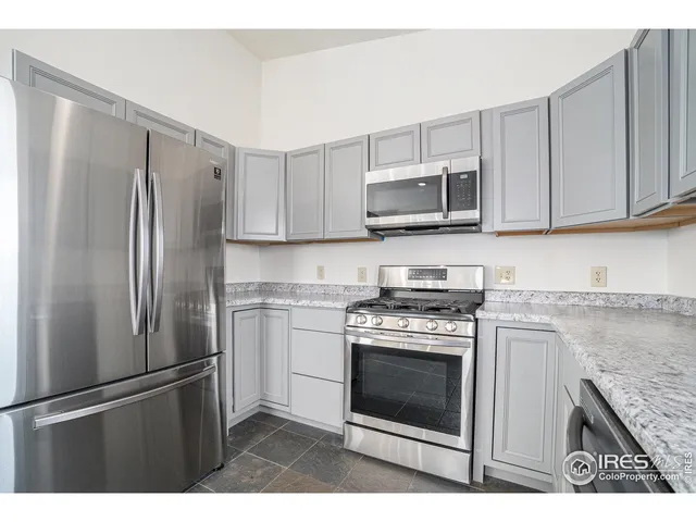 a kitchen with stainless steel appliances granite countertop a stove a refrigerator and a microwave