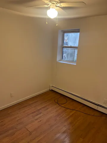a view of a room with wooden floor and a window