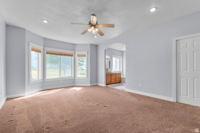 1501 West Elk Circle Mapleton, UT 84664 - Photo 23 of 39 Spacious room featuring light brown carpeting, a bay window with multiple panes, a ceiling fan with integrated lighting, and recessed ceiling lights