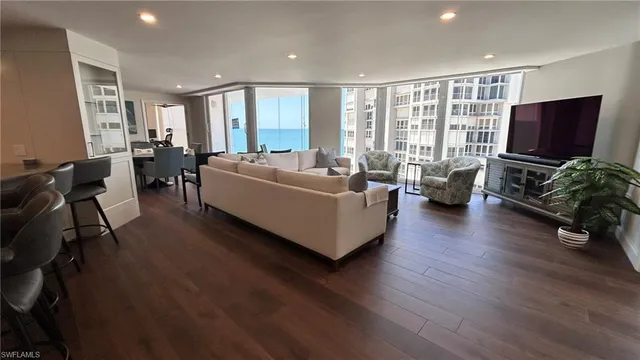 a living room with furniture wooden floor and a flat screen tv