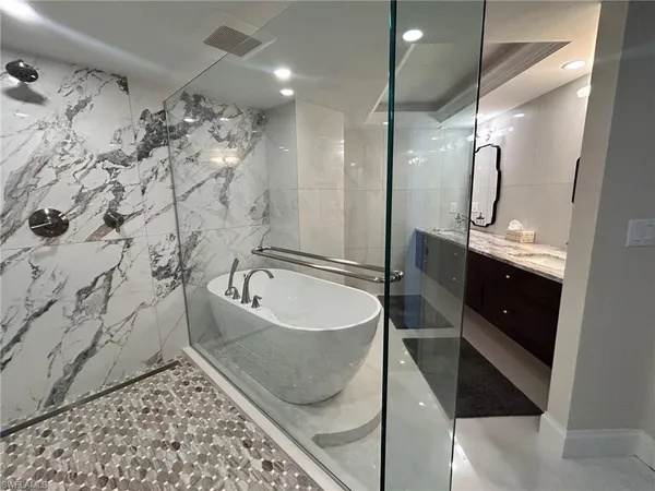 a bathroom with a bathtub sink shower and mirror