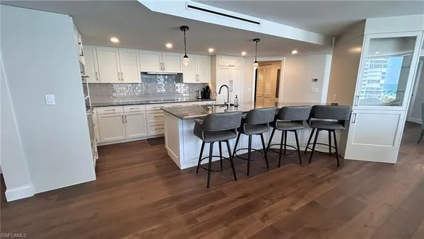 a large kitchen with a table and chairs