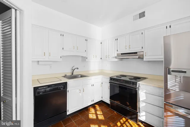 a kitchen with cabinets stainless steel appliances and a sink
