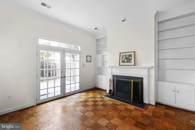a view of an empty room with a fireplace and a window