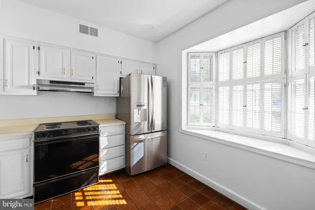 a kitchen with a stove a refrigerator and a window