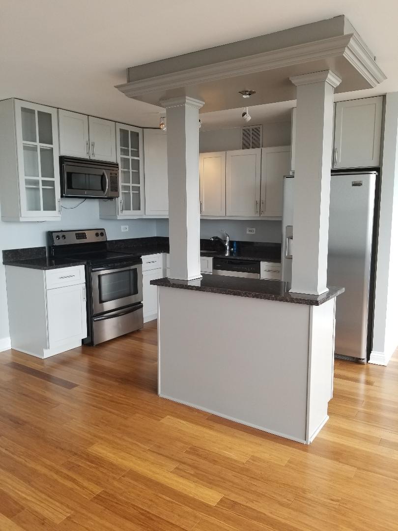 655 West Irving Park Road, Unit 5015 Chicago, IL 60613 - Photo 2 of 25 a kitchen with stainless steel appliances a refrigerator and a stove top oven