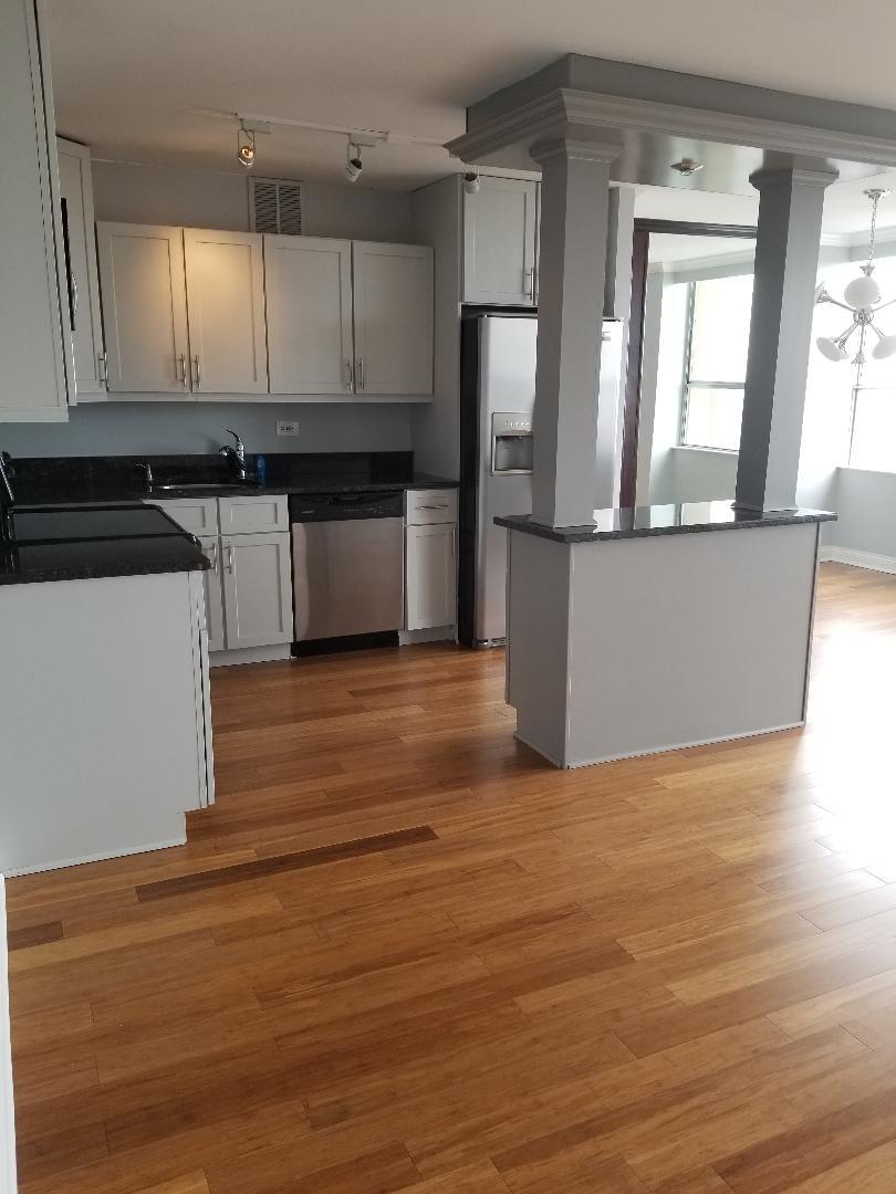 655 West Irving Park Road, Unit 5015 Chicago, IL 60613 - Photo 3 of 25 a kitchen with wooden floors and refrigerator