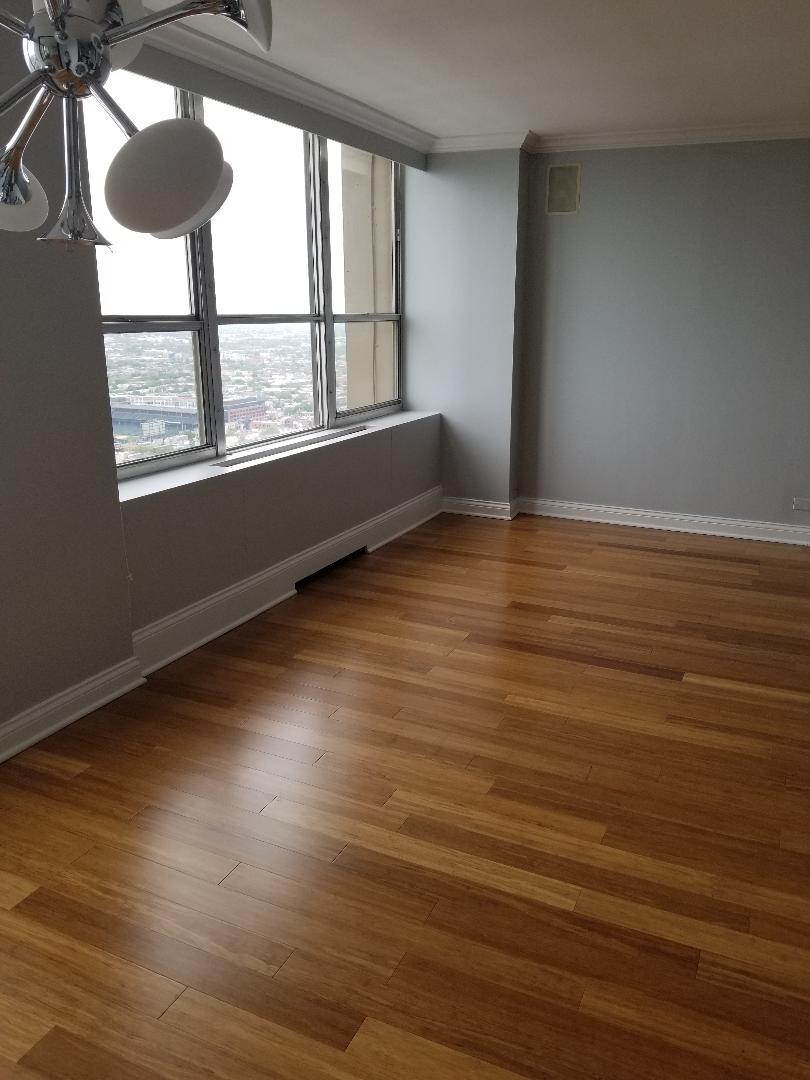 655 West Irving Park Road, Unit 5015 Chicago, IL 60613 - Photo 7 of 25 a view of an empty room with wooden floor and a window