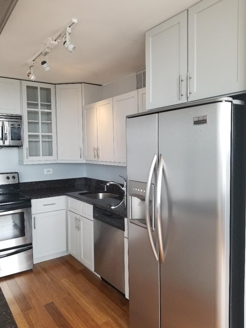 655 West Irving Park Road, Unit 5015 Chicago, IL 60613 - Photo 10 of 25 a kitchen with a refrigerator and a sink