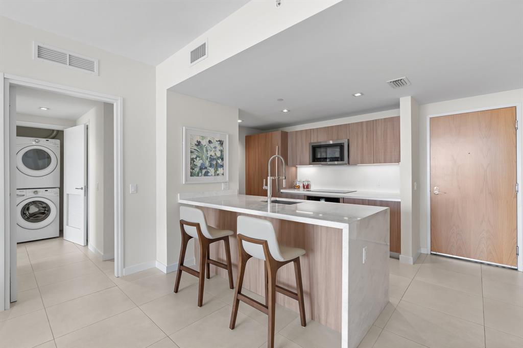 401 North Birch Road, Unit 1102 Fort Lauderdale, FL 33304 - Photo 15 of 31 a kitchen with stainless steel appliances granite countertop a stove top oven a sink a dining table and chairs