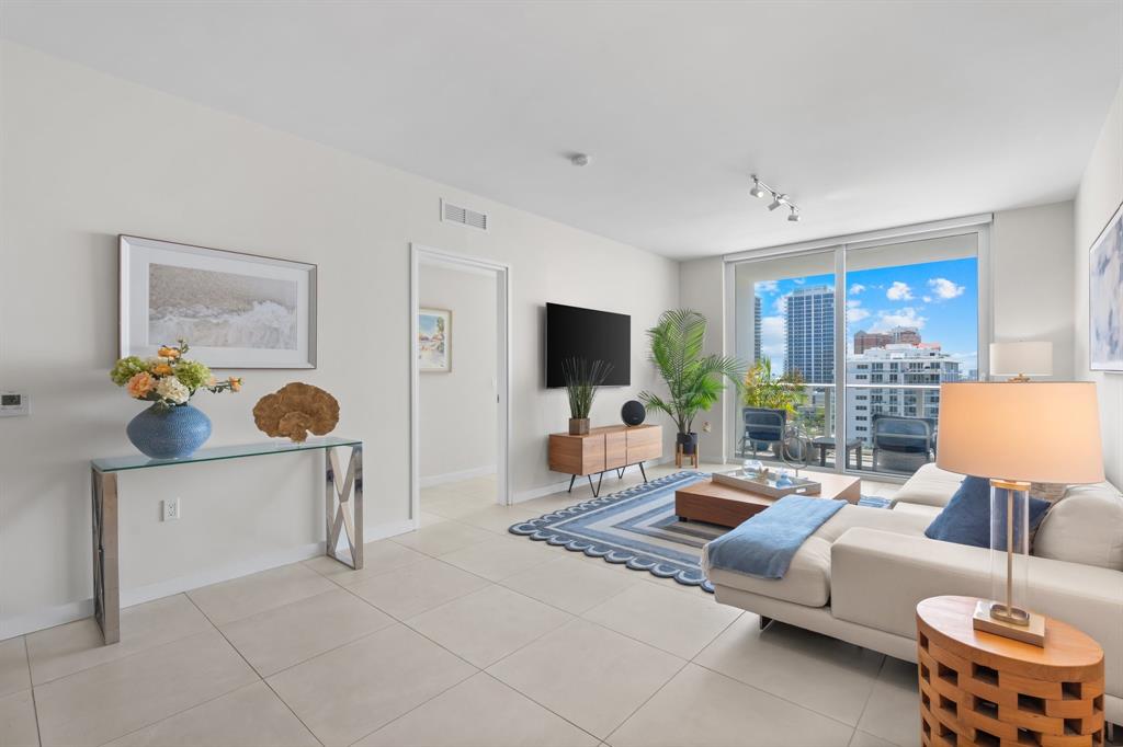 401 North Birch Road, Unit 1102 Fort Lauderdale, FL 33304 - Photo 3 of 31 a living room with furniture a flat screen tv and a large window