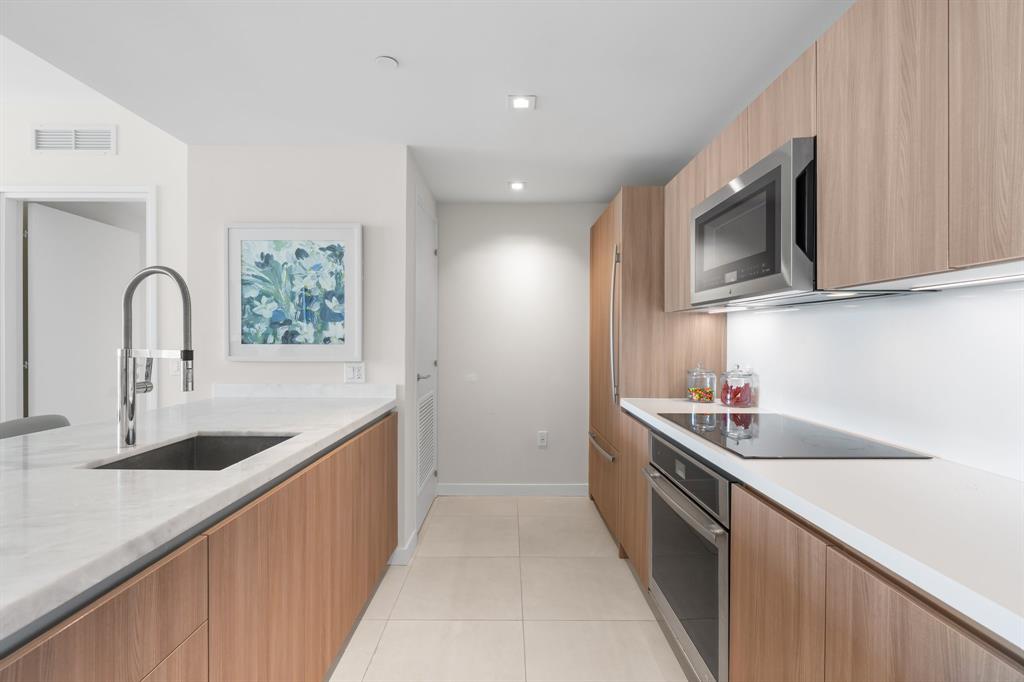 401 North Birch Road, Unit 1102 Fort Lauderdale, FL 33304 - Photo 5 of 31 a kitchen with stainless steel appliances granite countertop a sink a stove and a wooden floors