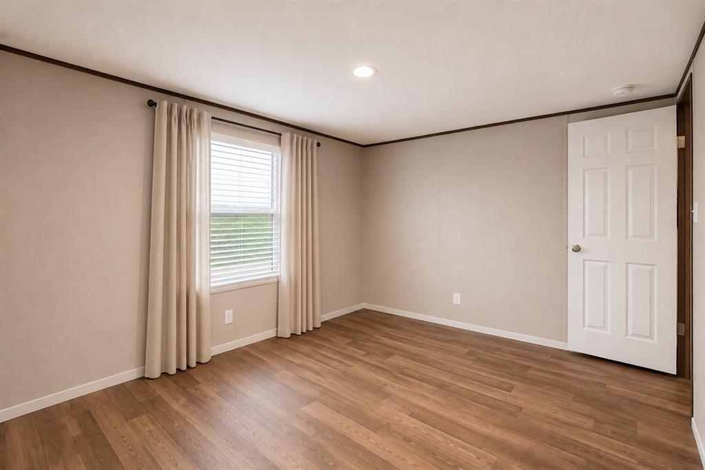 1206 Hayes Road Sherman, TX 75090 - Photo 14 of 21 an empty room with wooden floor and windows with curtains