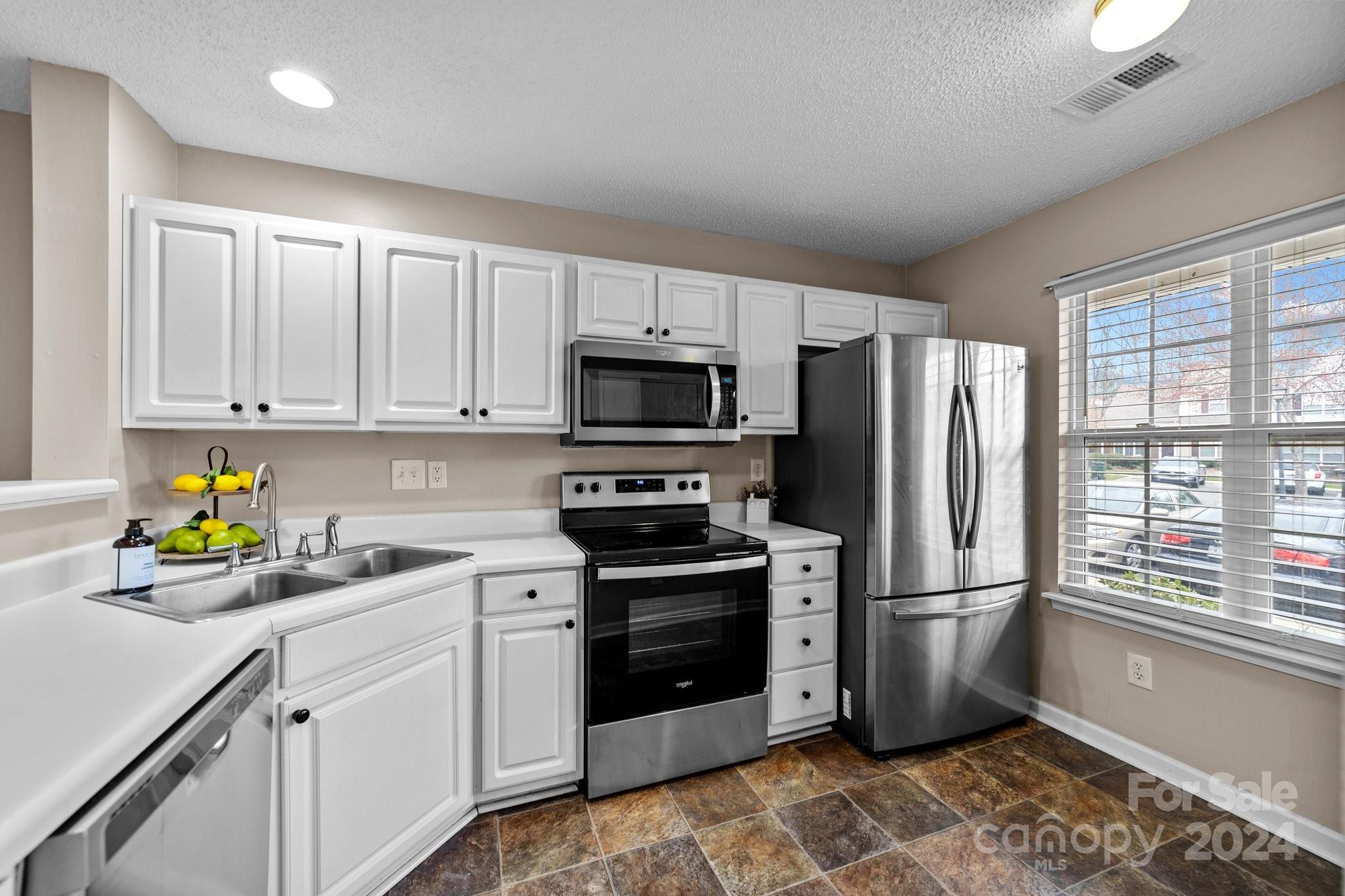 8368 Rudolph Road Charlotte, NC 28216 - Photo 12 of 43 a kitchen with a refrigerator and a stove top oven