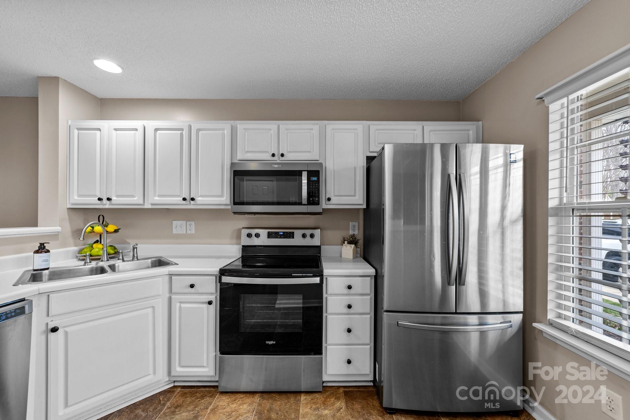 8368 Rudolph Road Charlotte, NC 28216 - Photo 16 of 43 a kitchen with stainless steel appliances a refrigerator stove and microwave