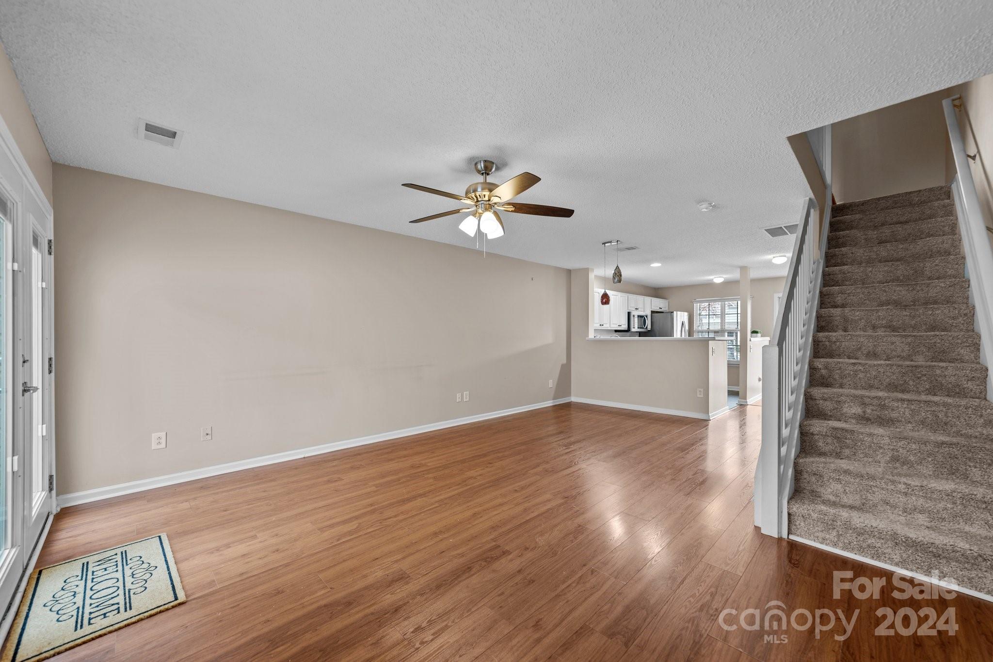 8368 Rudolph Road Charlotte, NC 28216 - Photo 22 of 43 a view of an empty room with wooden floor and a ceiling fan