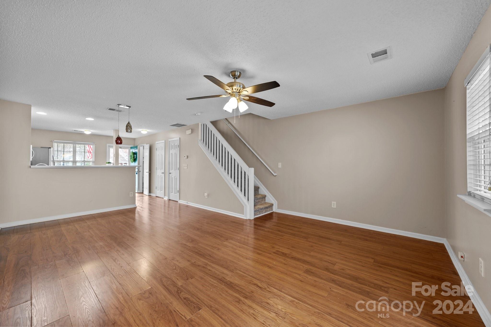 8368 Rudolph Road Charlotte, NC 28216 - Photo 23 of 43 a view of an empty room with wooden floor and a ceiling fan