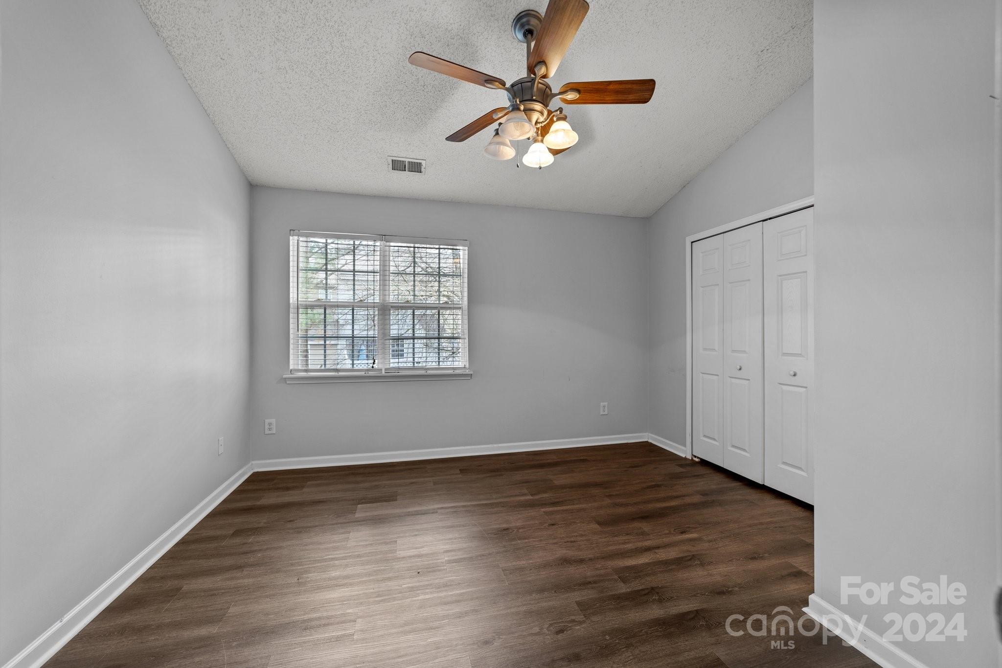 8368 Rudolph Road Charlotte, NC 28216 - Photo 28 of 43 an empty room with wooden floor chandelier fan and windows