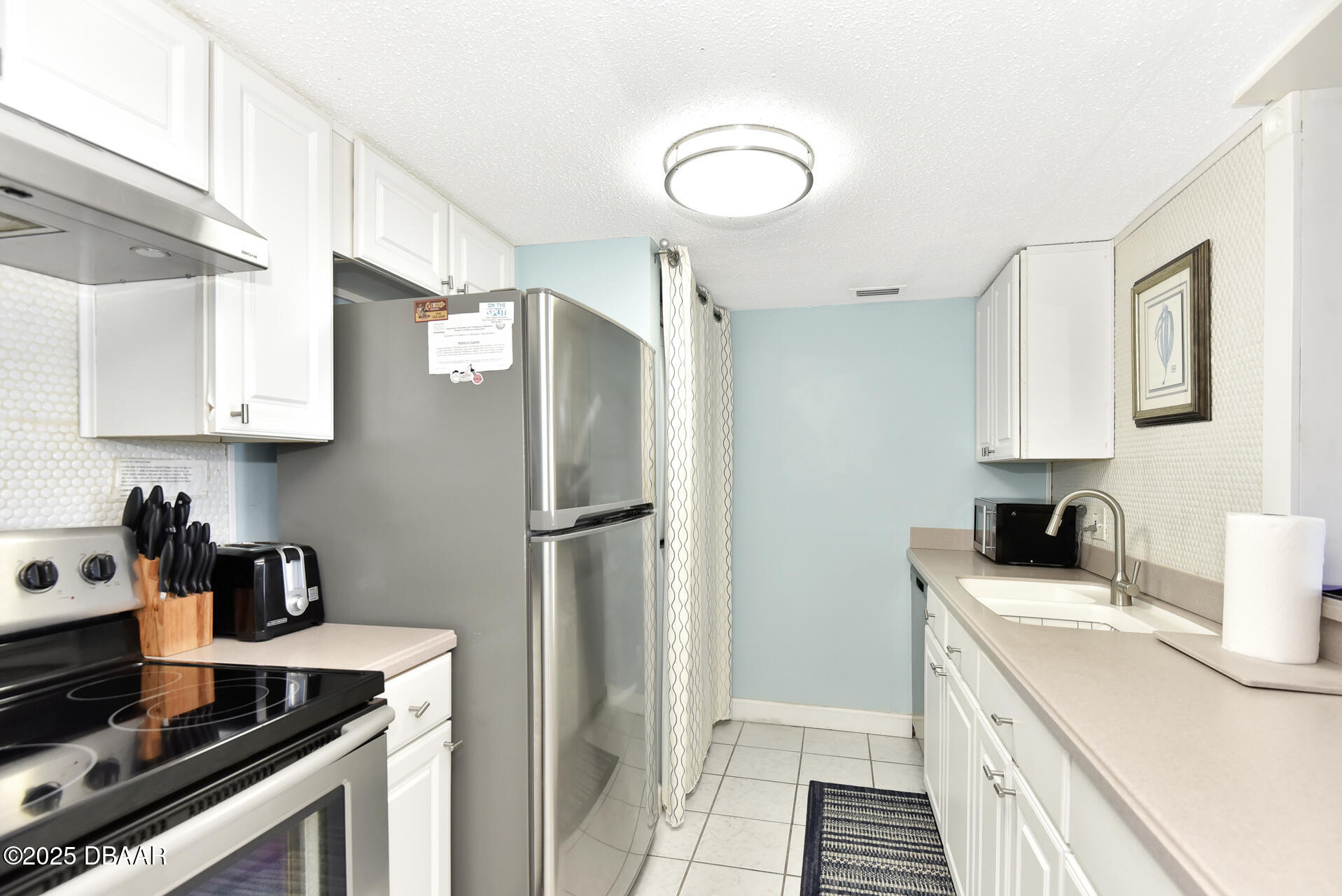 4495 South Atlantic Avenue, Unit 4040 Ponce Inlet, FL 32127 - Photo 13 of 45 a kitchen with a sink appliances and cabinets