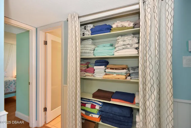 a bedroom with a bed and a flat tv screen on the dresser