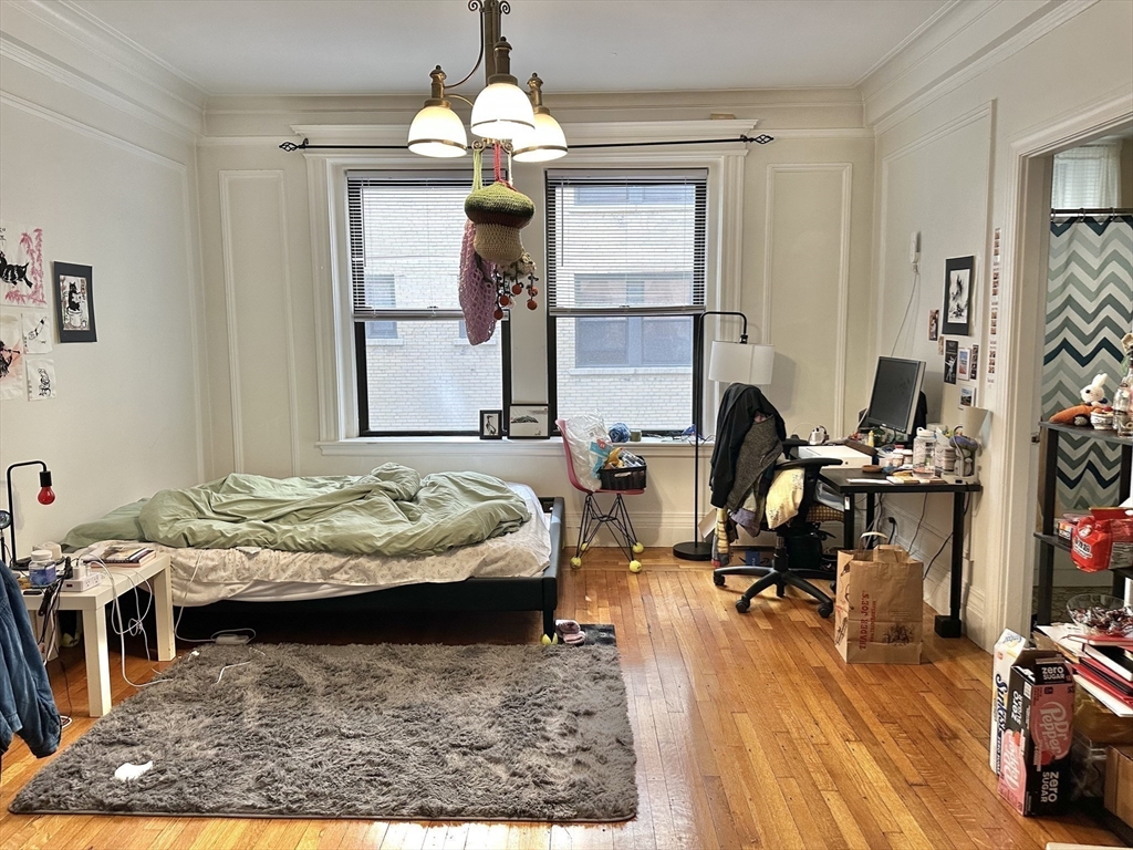 464 Commonwealth Avenue, Unit 38 Boston, MA 02215 - Photo 8 of 16 a bed room with furniture and a chandelier