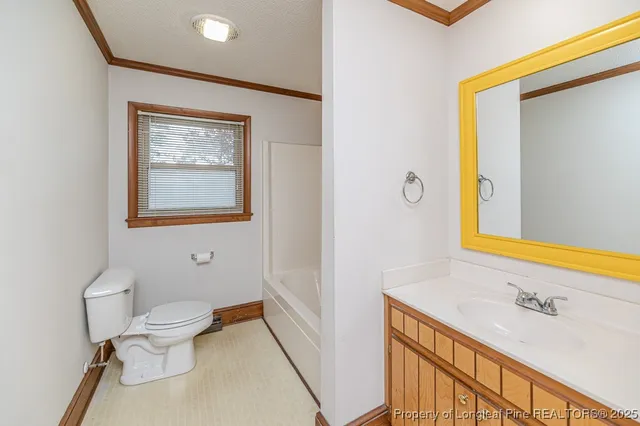 a bathroom with a granite countertop sink mirror vanity and toilet