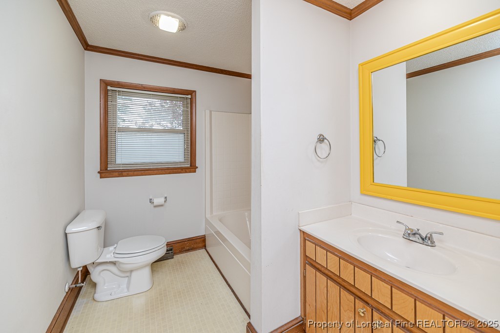 406 McFarland Road Broadway, NC 27505 - Photo 24 of 37 a bathroom with a granite countertop sink mirror vanity and toilet
