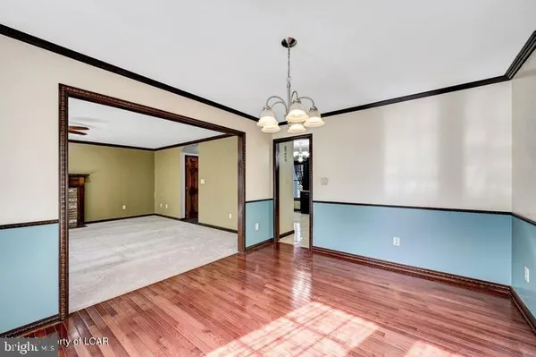 a kitchen with stainless steel appliances granite countertop a refrigerator oven a sink dishwasher a dining table and chairs with wooden floor