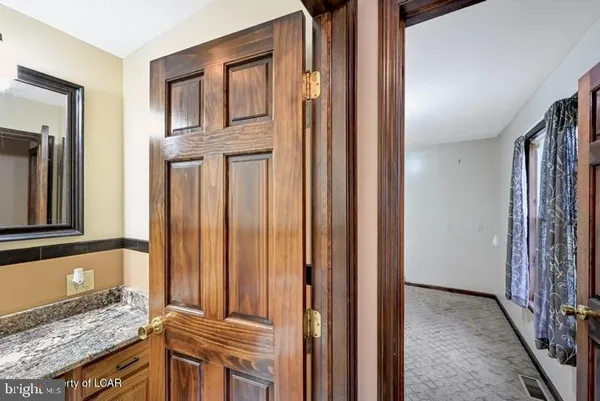 a bathroom with a granite countertop toilet sink and mirror