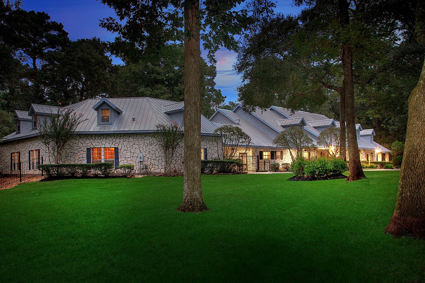 a view of a big house with a big yard and large trees