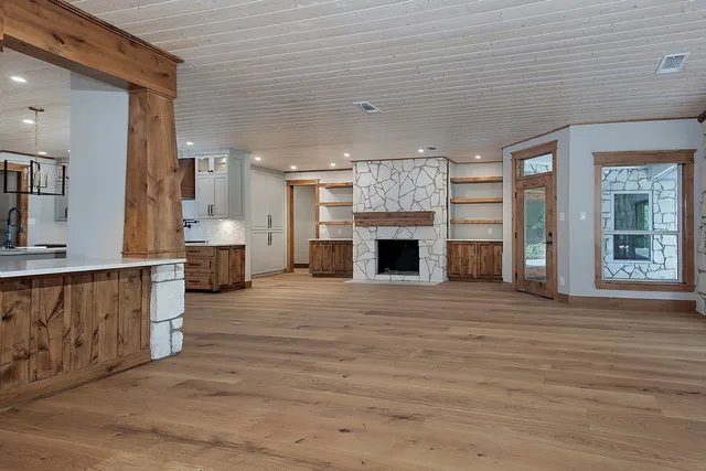 an empty room with wooden floor and fireplace