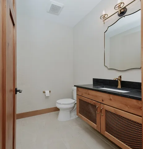 a bathroom with a sink a toilet and mirror