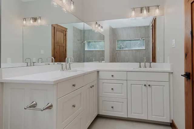 a bathroom with double sink and a mirror