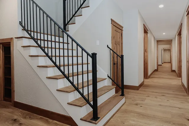 a view of staircase with lots of frames on wall and wooden floor