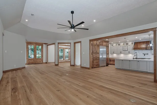 a view of a livingroom with wooden floor a fireplace and windows