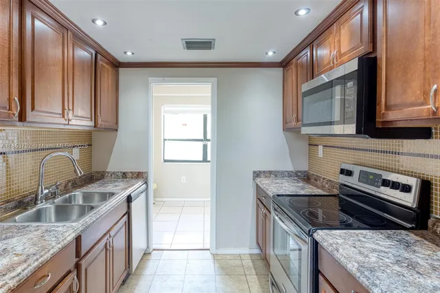 a kitchen with a sink refrigerator and cabinets