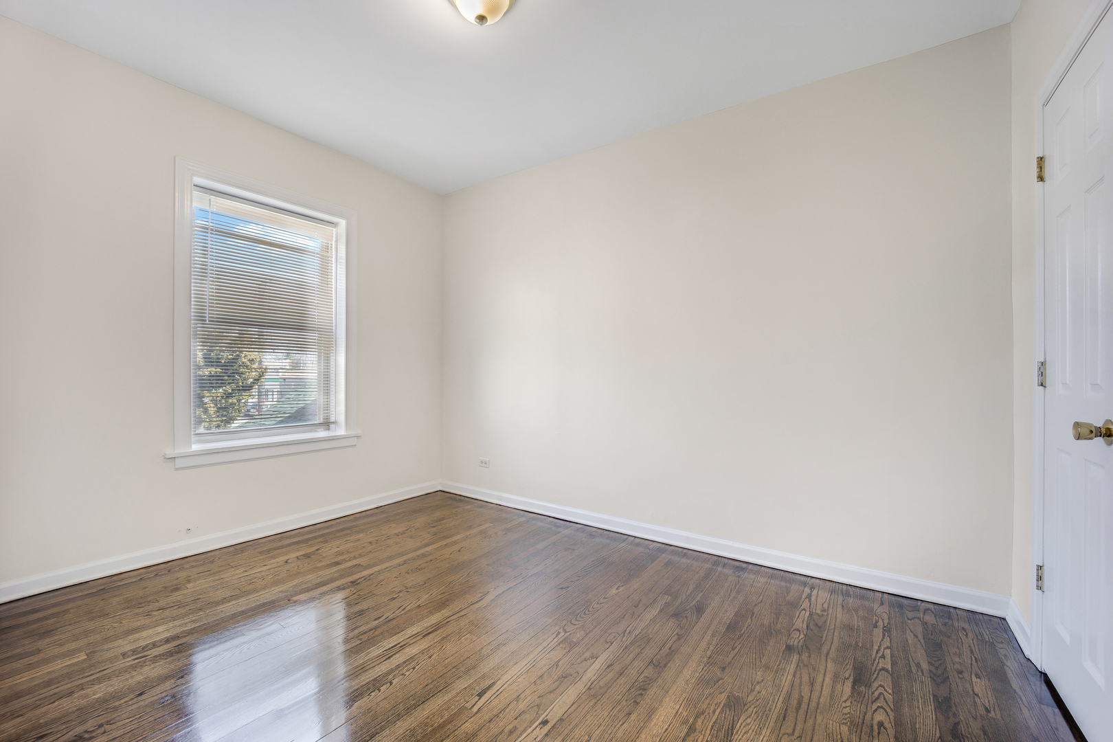 4452 West Parker Avenue, Unit 1 Chicago, IL 60639 - Photo 8 of 9 an empty room with wooden floor and windows
