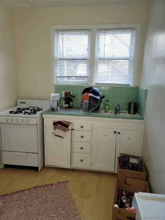 a kitchen with cabinets appliances and a window