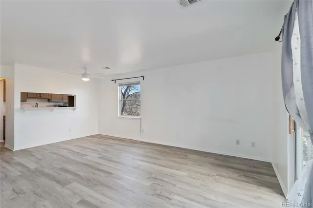 a view of empty room with wooden floor