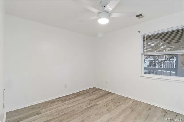 an empty room with a window and a fan