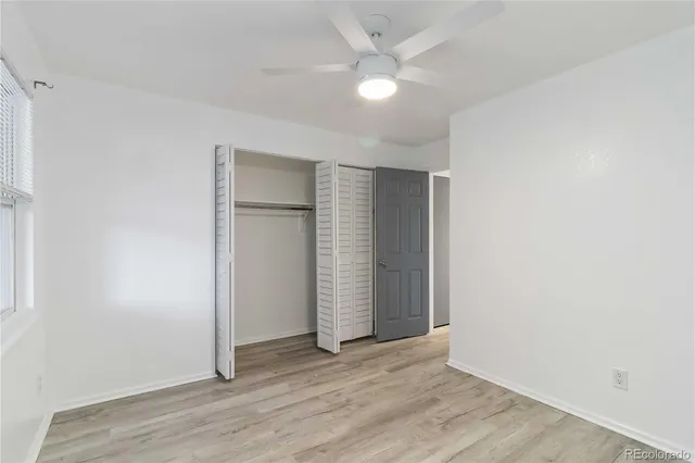 an empty room with wooden floor and window