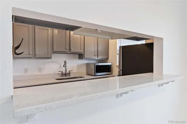 a kitchen with stainless steel appliances a microwave sink and cabinets