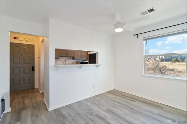 a view of a kitchen with wooden floor and a window