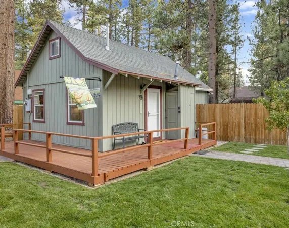 a view of backyard with wooden fence and a large tree